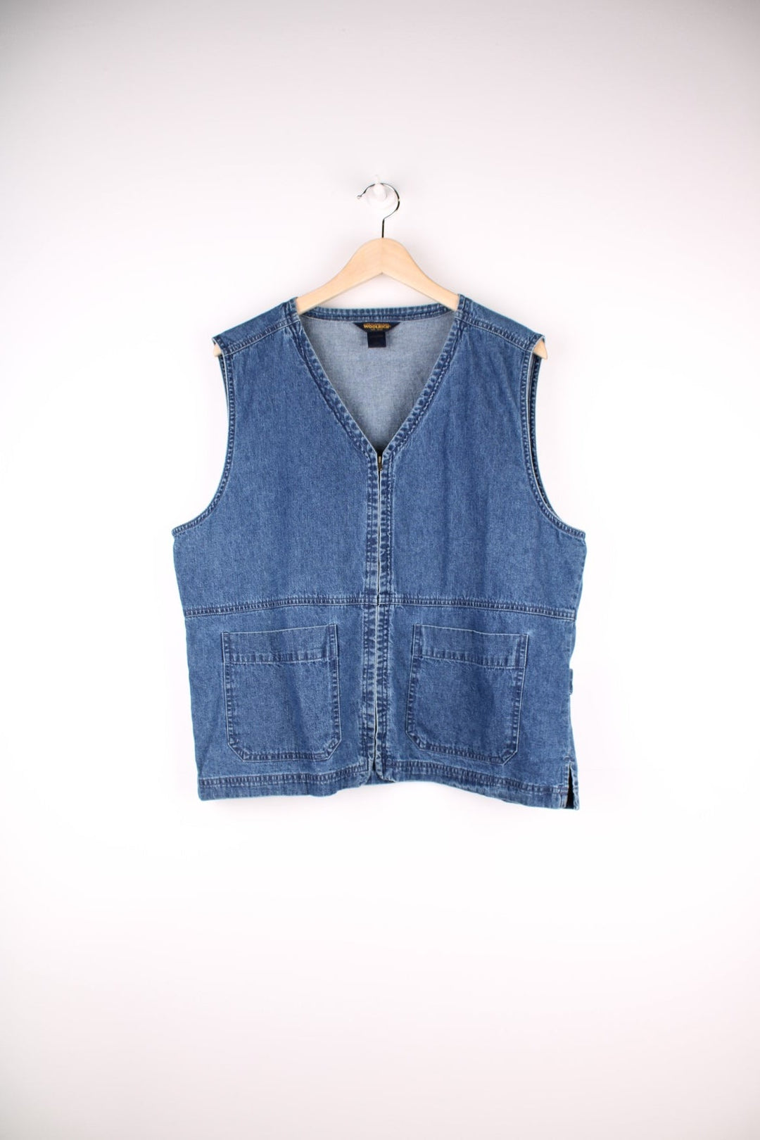 Woolrich Denim Vest in a blue colourway, zips up with a v neck collar and has double pockets on the front.