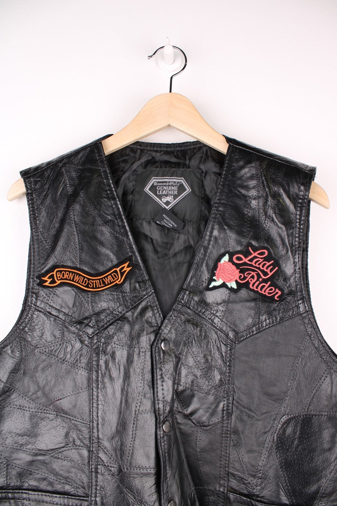Leather Biker Vest in a black colourway, button up with a v neck collar, and has multiple patches embroidered around the gilet.