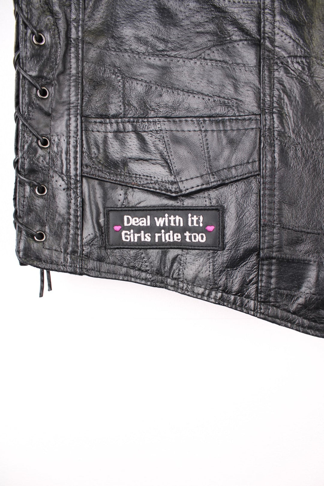 Leather Biker Vest in a black colourway, button up with a v neck collar, and has multiple patches embroidered around the gilet.