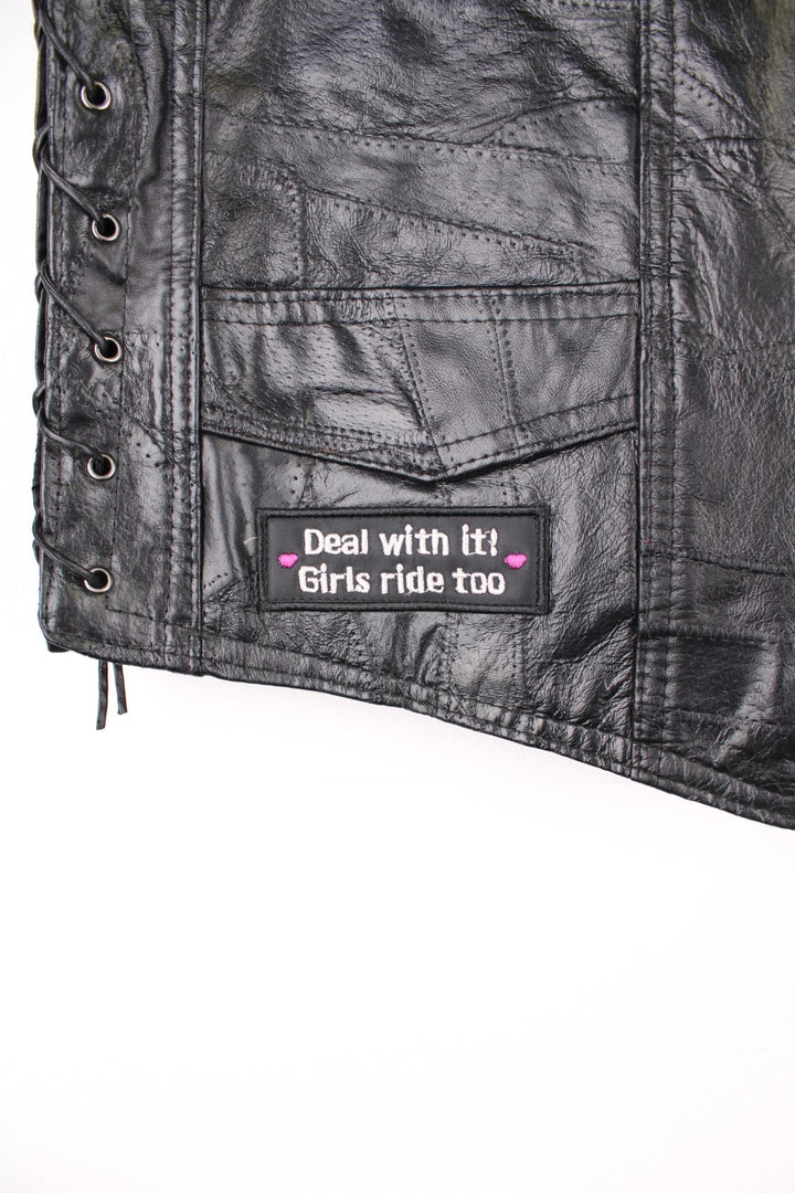 Leather Biker Vest in a black colourway, button up with a v neck collar, and has multiple patches embroidered around the gilet.