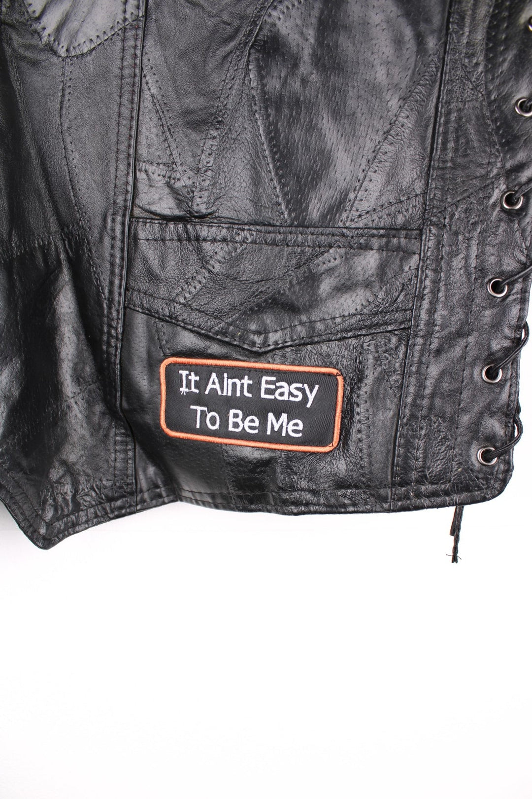 Leather Biker Vest in a black colourway, button up with a v neck collar, and has multiple patches embroidered around the gilet.