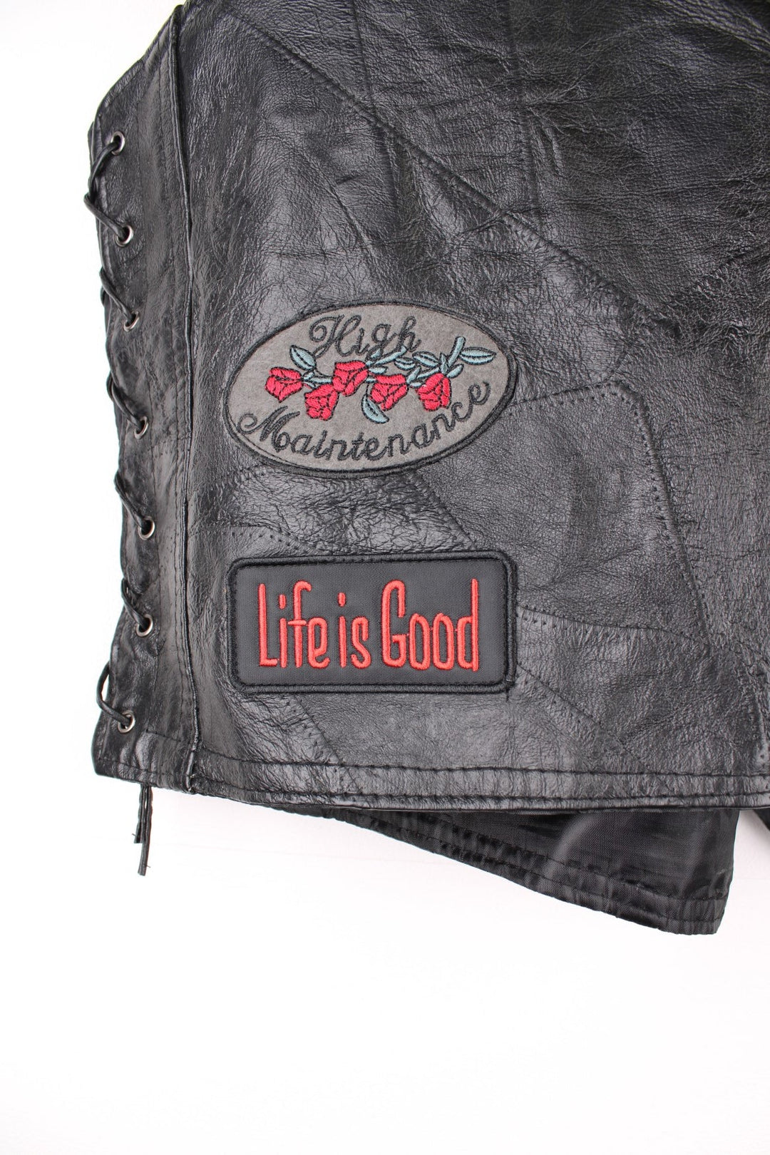 Leather Biker Vest in a black colourway, button up with a v neck collar, and has multiple patches embroidered around the gilet.