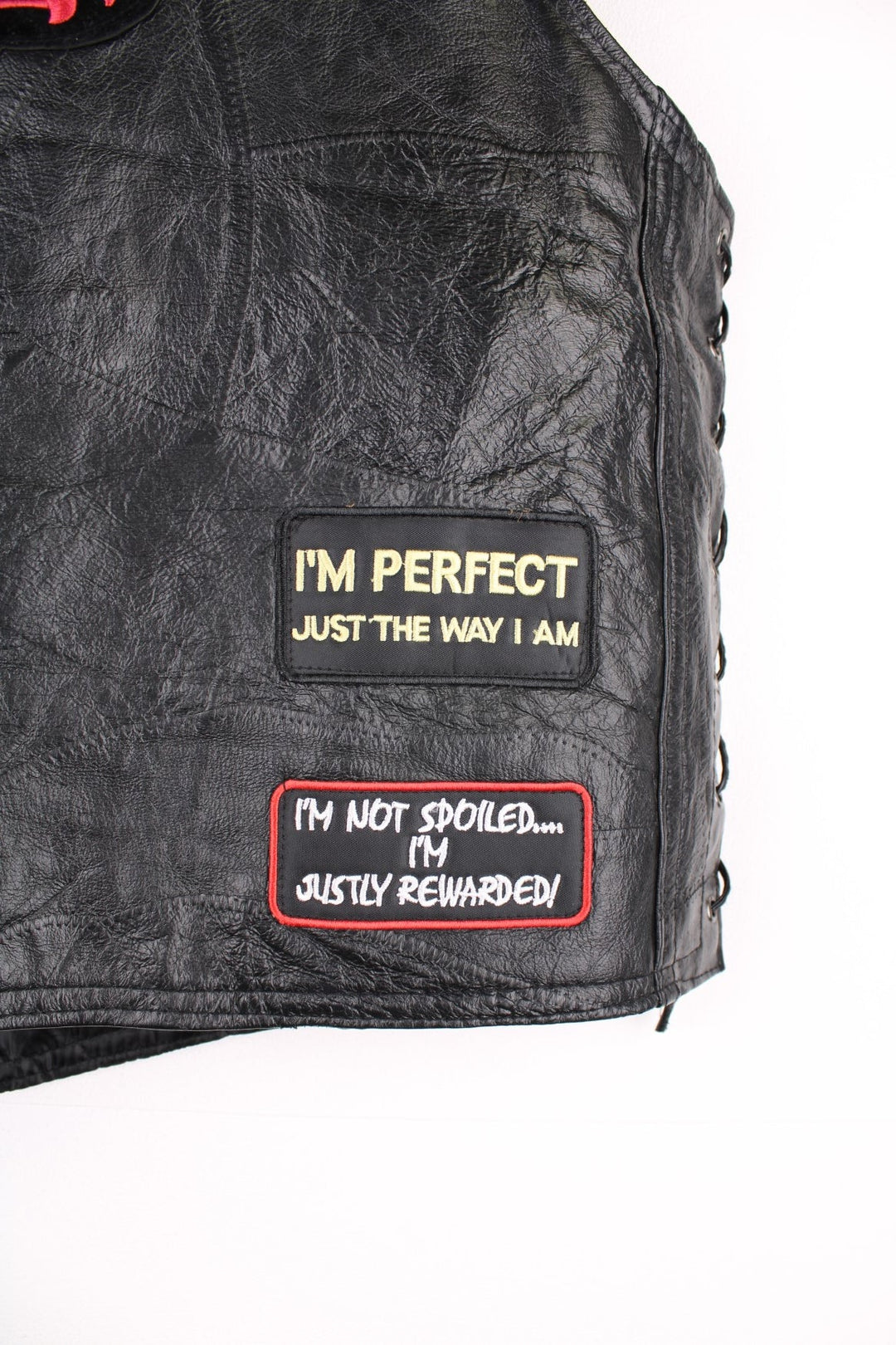 Leather Biker Vest in a black colourway, button up with a v neck collar, and has multiple patches embroidered around the gilet.