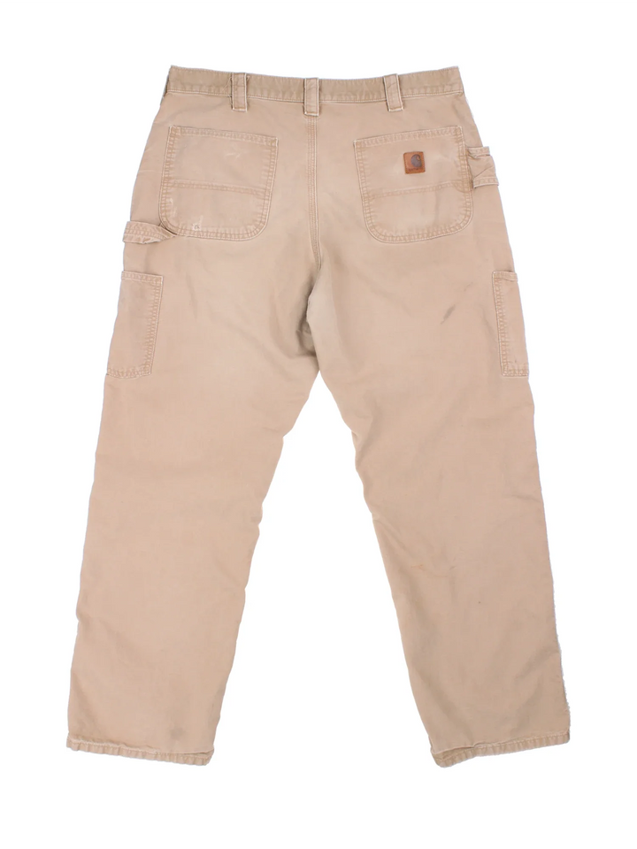 Carhartt Trousers in tan colourway with multiple pockets and the logo embroidered on the back.