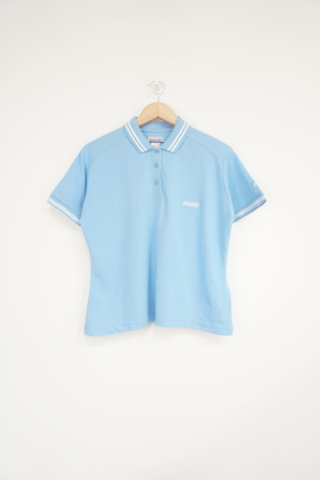 Baby blue Reebok polo shirt with embroidered logo on the chest