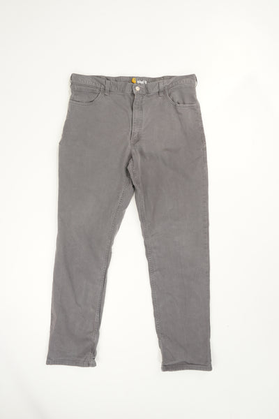 Stone grey Carhartt relaxed fit straight leg jeans with signature logo on the back pocket