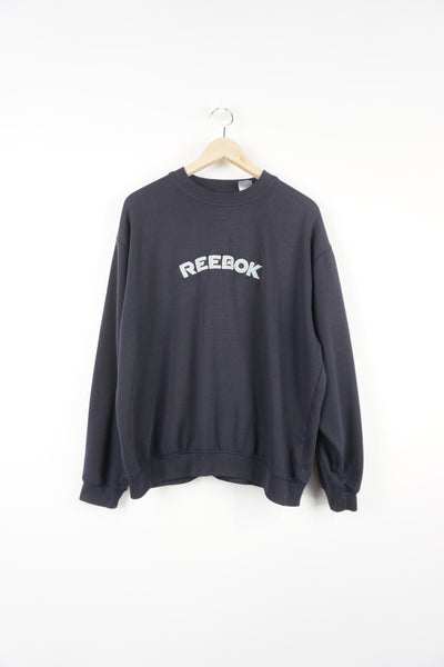 Navy blue Reebok sweatshirt features embroidered spell-out logo across the chest