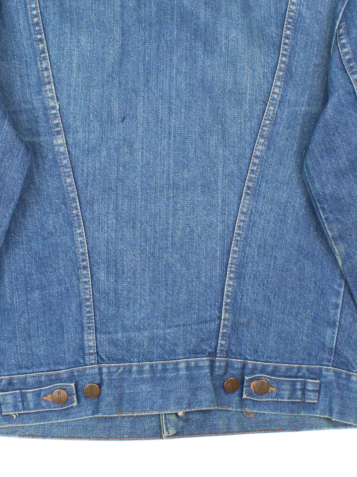 Vintage Wrangler Denim Jacket in a blue colourway. Buttons up and has multiple pockets, and the logo tab embroidered on the front.