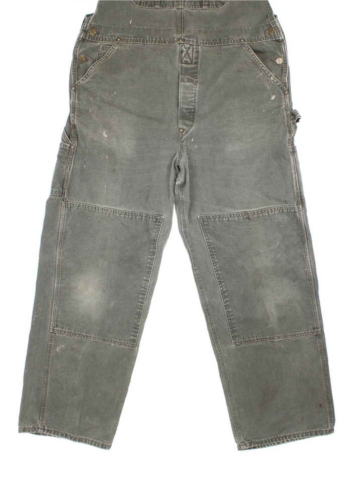 Carhartt Dungarees in green colourway with multiple pockets, adjustable straps and the logo embroidered on the front.