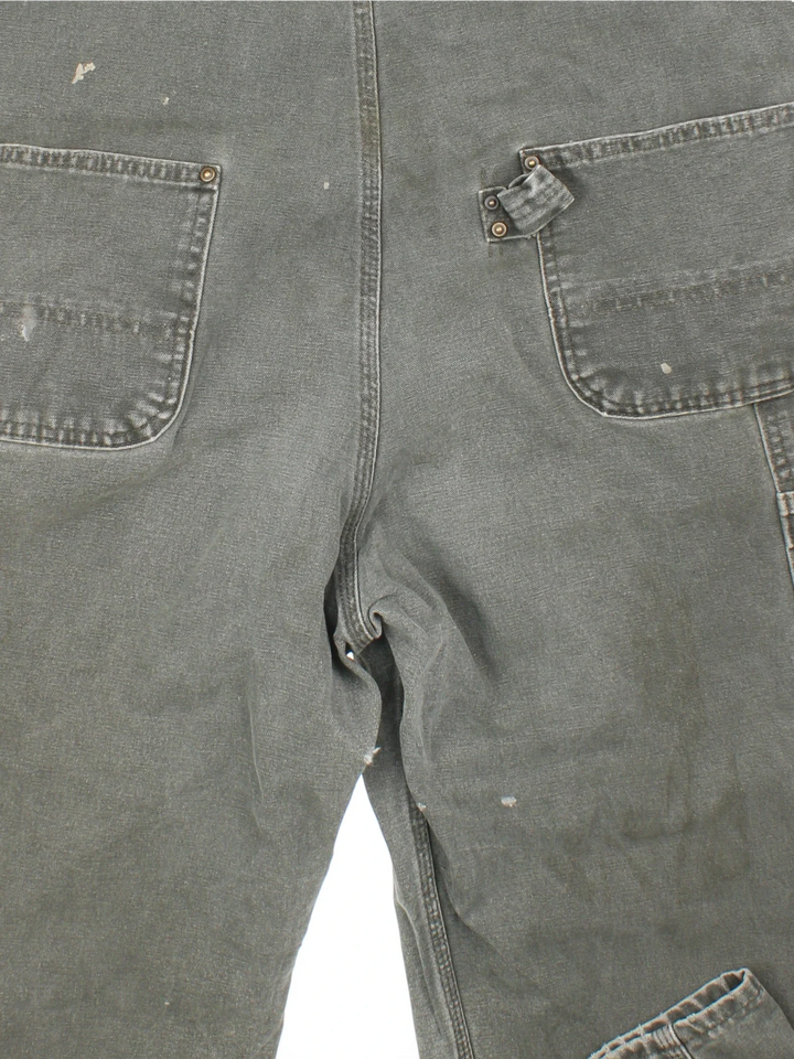 Carhartt Dungarees in green colourway with multiple pockets, adjustable straps and the logo embroidered on the front.