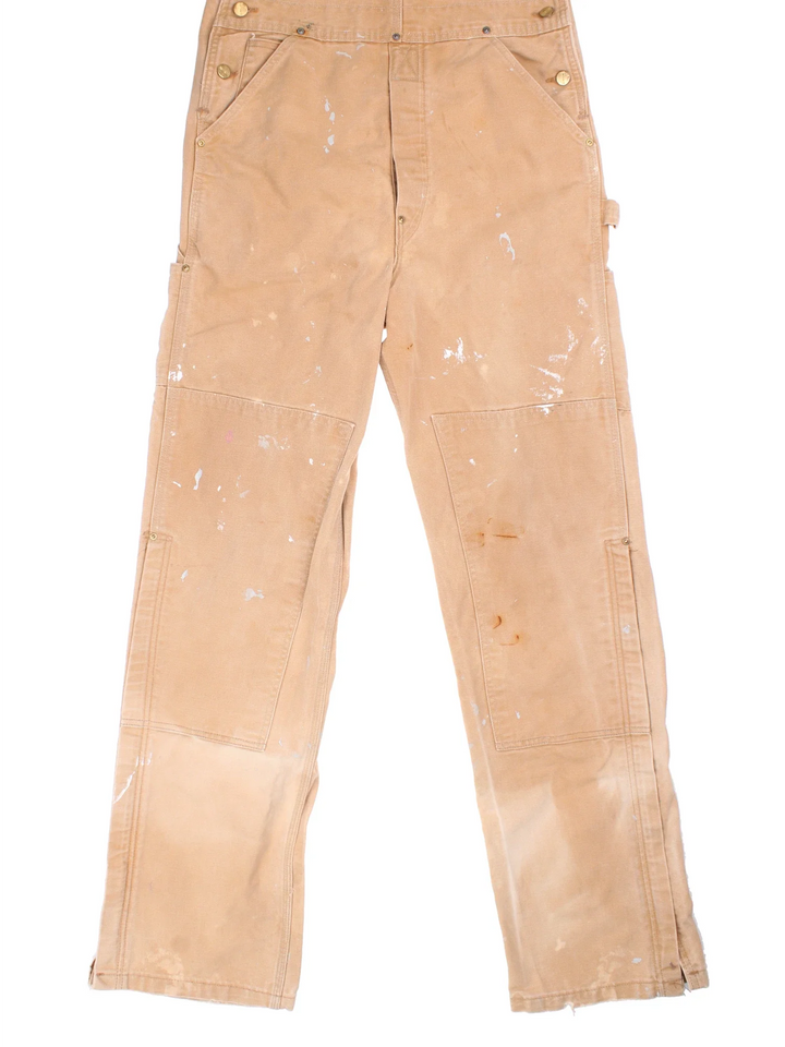 Carhartt Dungarees in tan colourway with multiple pockets, adjustable straps and the logo embroidered on the front.