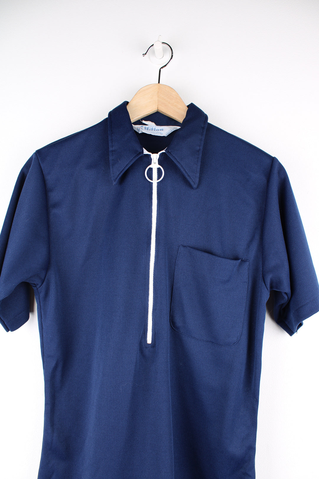 Vintage 1960's/70's made in the USA Hilton Bowling shirt in navy blue. Features 1/4 zip, dagger collar and printed spell-out on the back