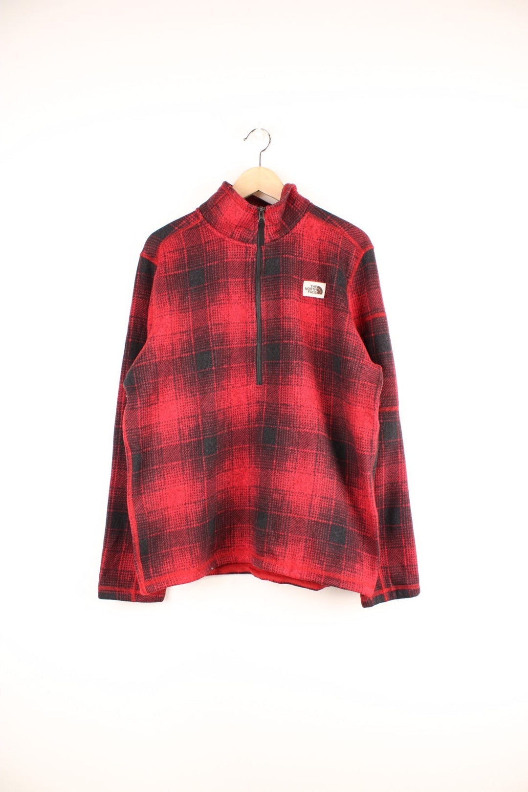 The North Face red and black check fleece with 1/2 zip closure and a white logo patch.