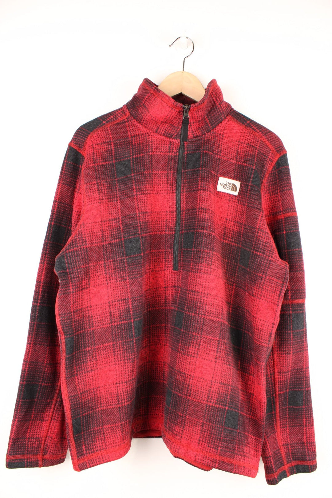 The North Face red and black check fleece with 1/2 zip closure and a white logo patch.