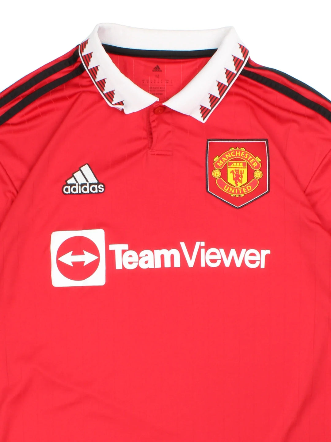 Manchester United 2002/23 Adidas Football Shirt in the red home kit colourway, features printed logos and badge on the front with the classic adidas 3 stripe on the sleeve and button collar.