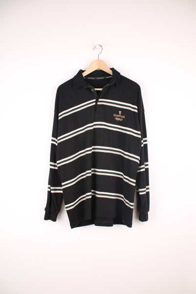 Guinness Polo Shirt in a black, white and green striped colourway, button up with a collar, and has the logo embroidered on the front. 