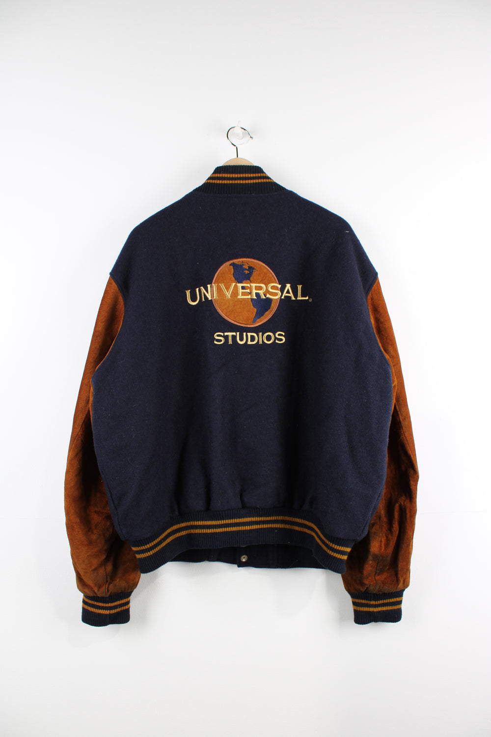 Vintage 00's Universal Studios blue and brown varsity jacket. Has a quilted lining and embroidered logo both on the front and back of the jacket.