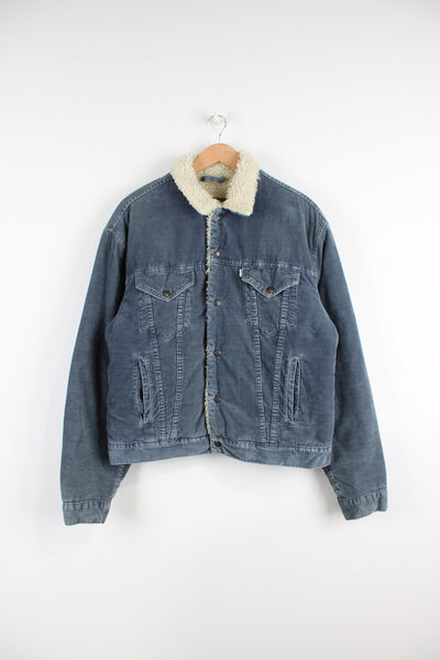 Levi's corduroy jacket in blue, button up with multiple pockets, and has a white sherpa lining. 