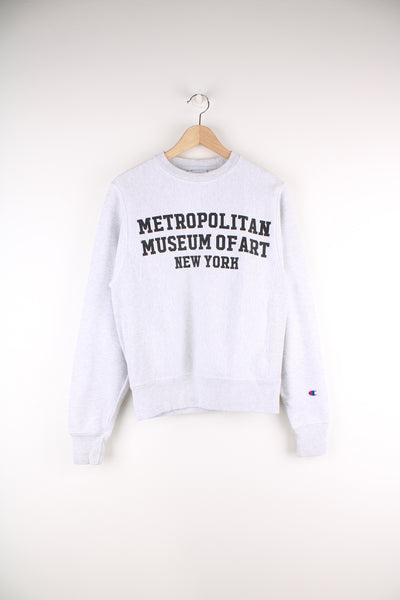 Champion Reverse Weave, Metropolitan Museum Of Art New York Sweatshirt in a grey and black colourway, big spell out printed across the front as well as the Champion logo embroidered on the left sleeve.
