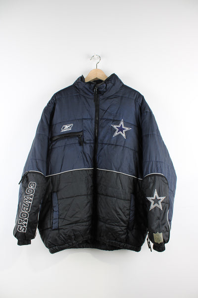 NFL Dallas Cowboys padded sports coat by Reebok with embroidered team badge and logos. Has zip compartment on the forearms.  good condition - very small hole on one of the arms above the NFL logo.   Size in Label:  Mens XL  Our Measurements:  Chest: 27 inches Length: 29 inches