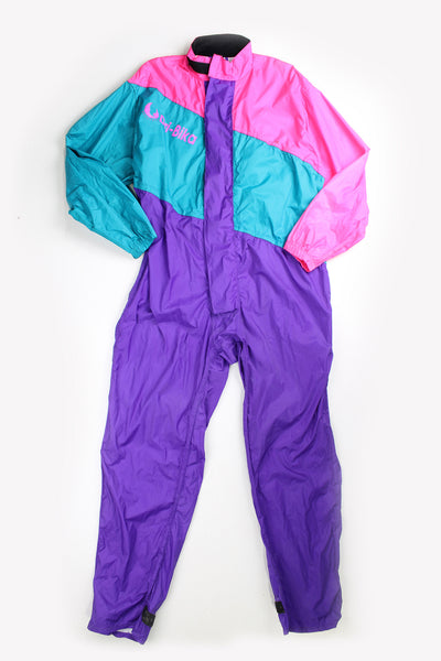 Vintage 80's Belstaff Dri Bika fold away waterproof coveralls. Pink and purple jumpsuit that folds away into a bag. Due to age the effectiveness of the waterproof fabric might be less. good condition - small mark on the front, scratches to the inside lining and some external scuffs Size in Label: Size L
