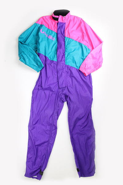 Vintage 80's Belstaff Dri Bika fold away waterproof coveralls. Pink and purple jumpsuit that folds away into a bag. Due to age the effectiveness of the waterproof fabric might be less.  good condition - small mark on the front, scratches to the inside lining and some external scuffs Size in Label: Size L 