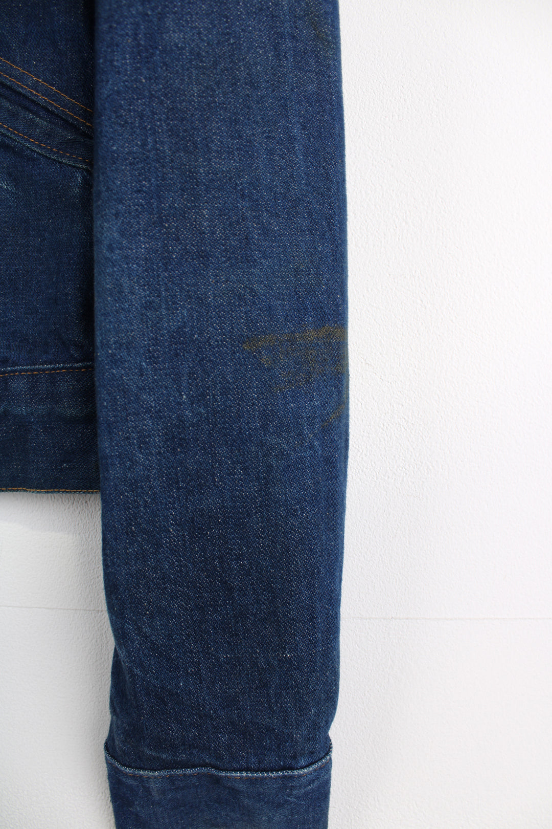 Vintage Wrangler Denim Jacket in a blue colourway with brown cross stitching, button up, multiple pockets, and has logo embroidered on the chest.