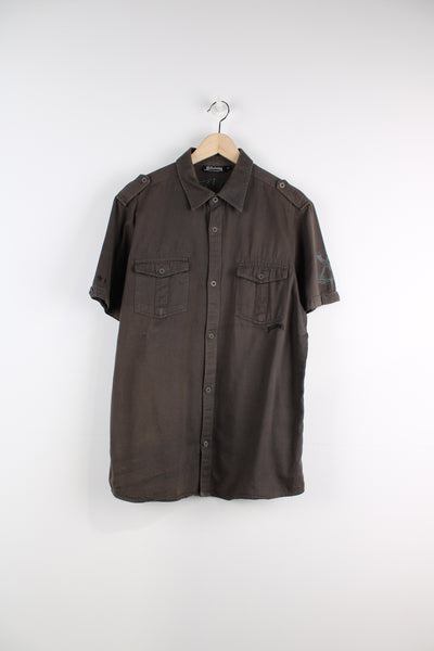 Billabong Short Sleeved Shirt in a khaki and grey colourway, button up, double chest pockets, and has logo embroidered on the front and big back graphic.