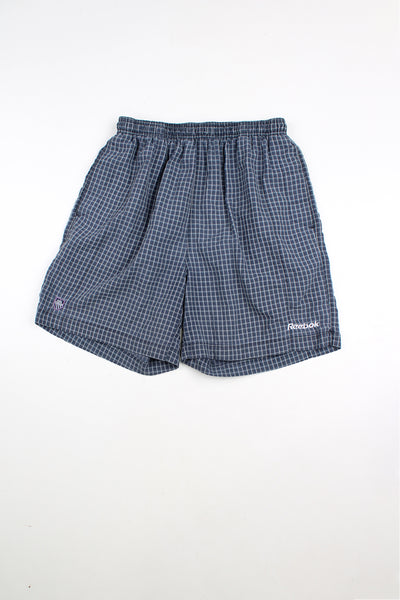 Blue and grey Reebok checked shorts with elasticated waist and drawstring. Features embroidered logo and embroidered "M.C.F.C" badge.