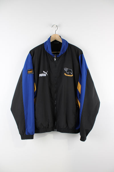 Vintage Derby County 1995/97 Puma tracksuit top in a black and blue colourway, zip up jacket with two side pockets, has embroidered logos on the front and back.