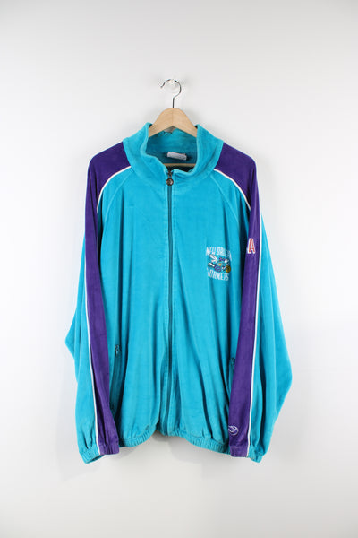Vintage Charlotte Hornet NBA track jacket, blue, purple and white team colourway, zip up with side pockets, logo embroidered on the front and Hornets spell-out on the back.