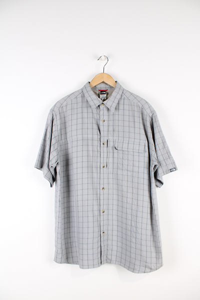 The North Face grey plaid, button up cotton shirt. Features velcro closure chest pocket and spell-out logo on the sleeve