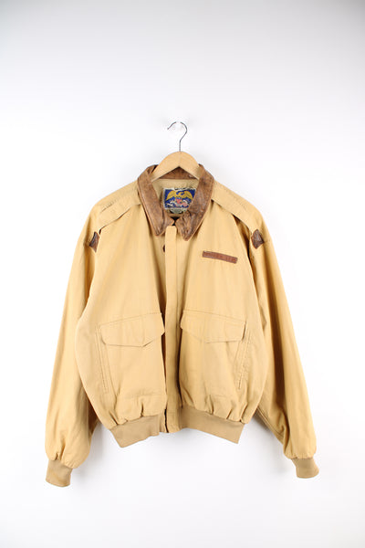 Vintage Avirex tan cotton zip through flight/bomber jacket, features multiple pockets and leather embossed logo on the chest