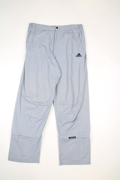 Vintage Adidas tracksuit bottoms in a grey colourway, elasticated waist, multiple pockets,  has logo embroidered on the front and detachable zip on the legs to make them quarter length. 