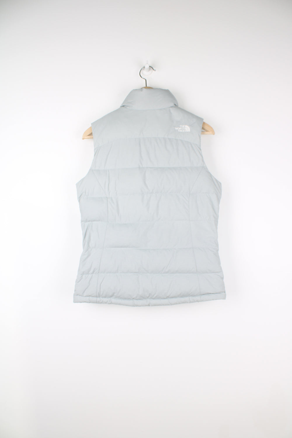 The North Face Face puffer gilet in a grey, zip up with side pockets, insulated and has logo embroidered logo on the front and back.