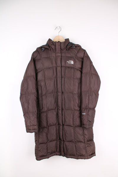 The North Face long puffer jacket in brown, zip up, hooded, insulated and has logo embroidered on the front and back. 