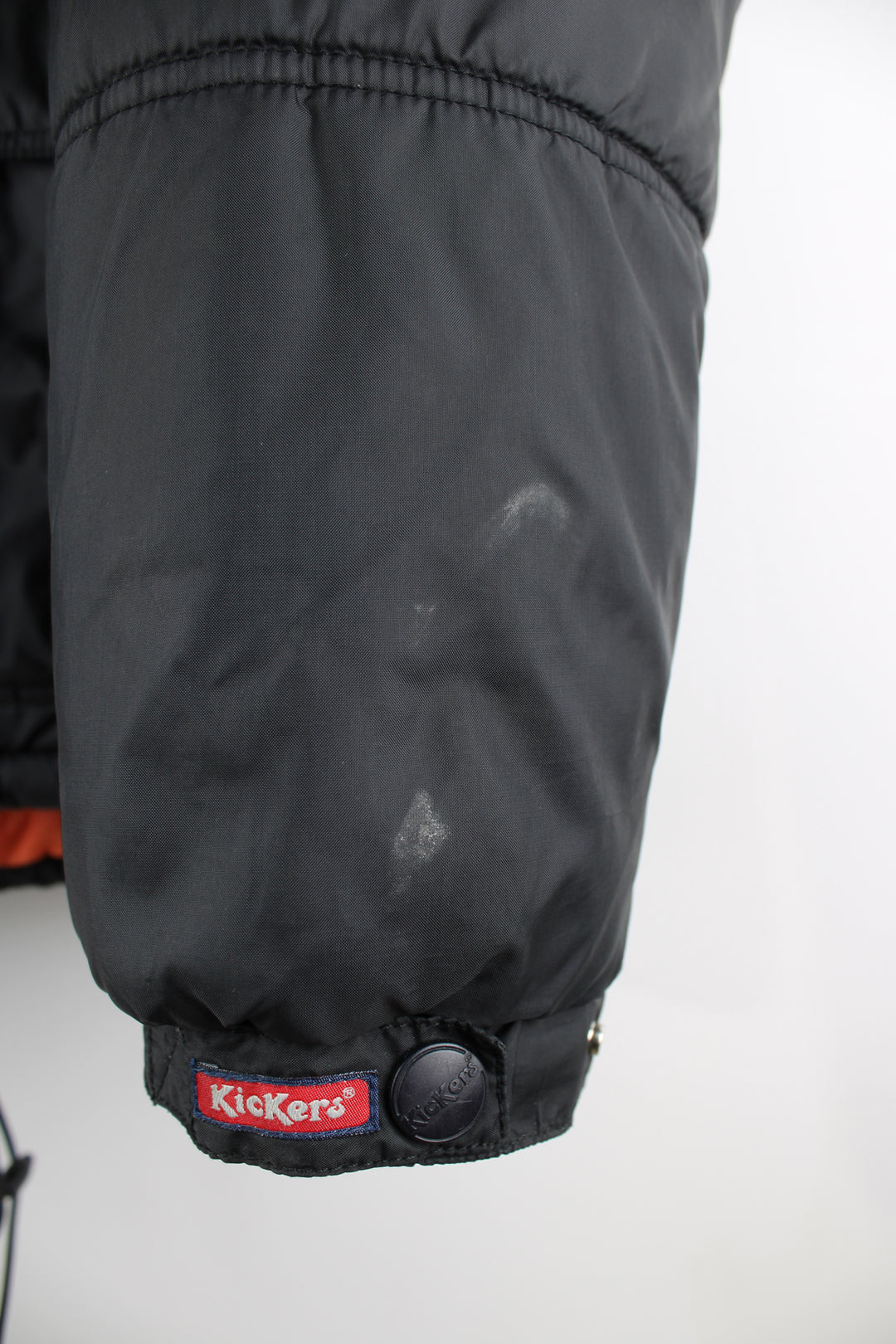 Vintage Kickers puffer jacket in black, zip up, insulated, multiple pockets, hooded and has the logo embroidered on the front.