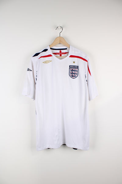 Vintage England 2007/09, Umbro Home Football Shirt, white, blue and red colourway, v neck, and has printed logos on the front. 