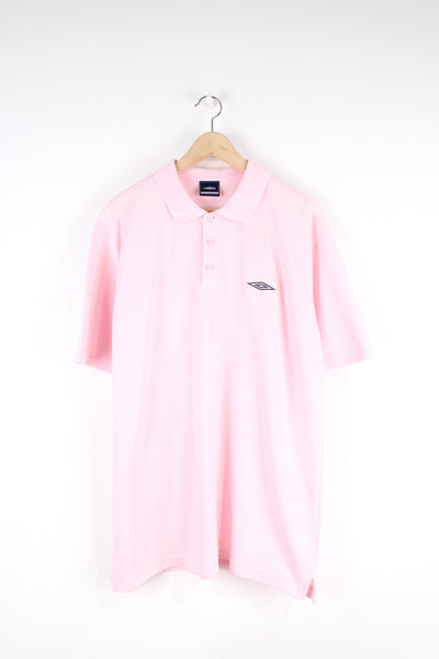 Vintage Umbro polo shirt in pink, button up with a collar, striped fabric, and has the logo embroidered on the chest.