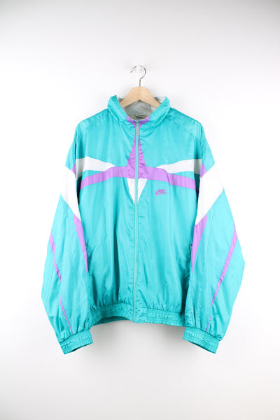 Vintage Nike Shell Jacket in a blue, purple and white patterned colourway, zip up, side pockets, and has the logo embroidered on the front.
