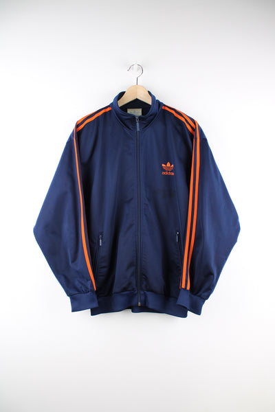 Adidas Tracksuit Jacket in a blue and orange colourway, zip up, side pockets, and has the logo embroidered on the front.