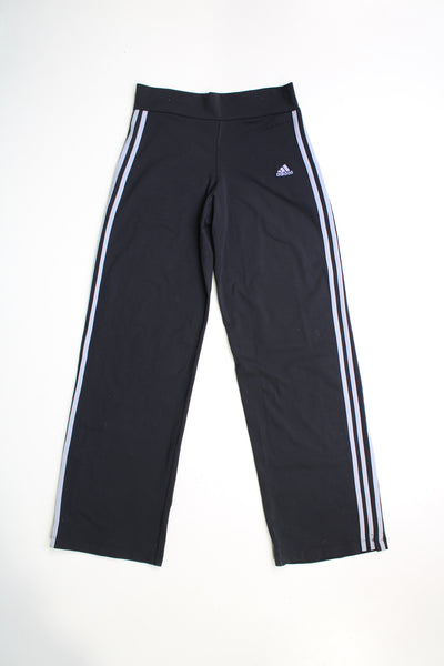 Vintage 00's black Adidas legging style tracksuit bottoms. Feature embroidered logo on the front embroidered grey three stripe detail down the sides. Made from a stretchy fabric with a slightly flared leg.   good condition  Size in Label:  Womens M