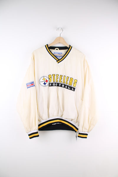 Vintage Pittsburg Steelers cream/off white nylon pullover training top by Starter with embroidered spell-out details across the chest and logo on the cuff 