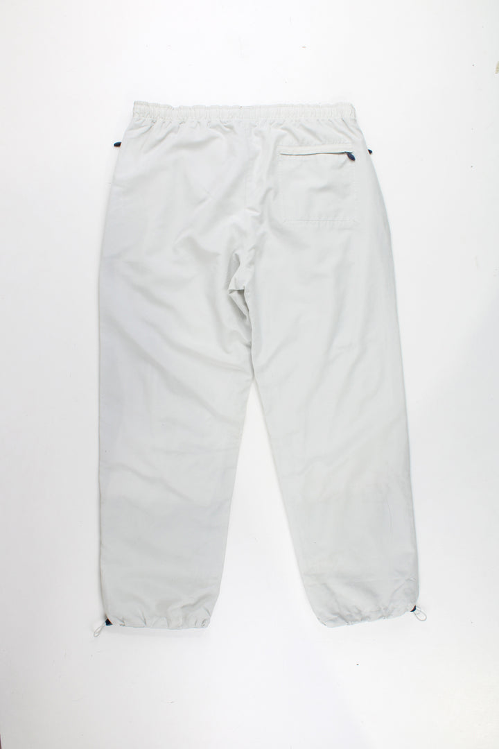 Reebok Tracksuit Bottoms in a tan colourway, has a elasticated waist, multiple pockets, and logo embroidered on the front.