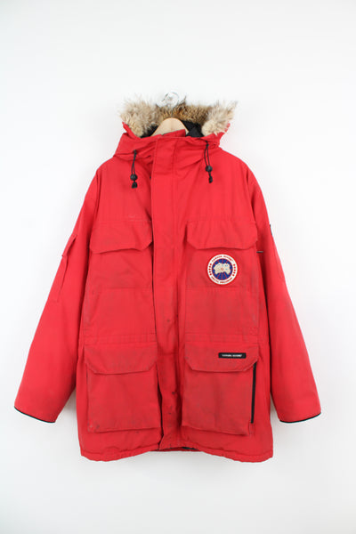 Canada Goose red expedition parka coat, with multiple pockets, fur trim hood and duck down filling.