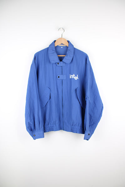Vintage 90's blue Windbreaker/ bomber jacket with printed "Intel" logo on the chest and back. Closes with a zip and popper buttons.  good condition  Size in Label: Mens XXL - Measures more like a mens XL
