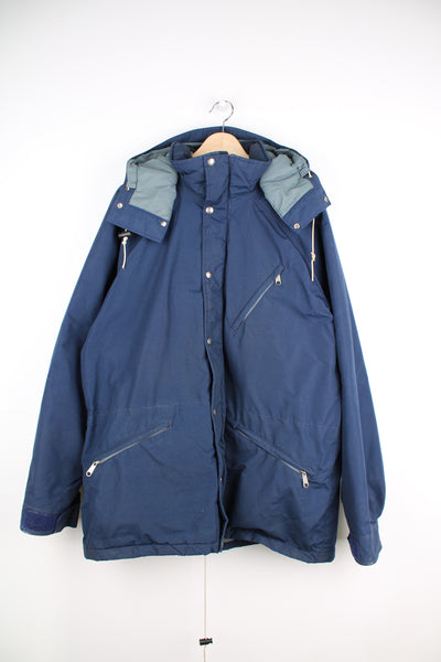 The North Face Goretex Jacket in a blue colourway, parka style, zip up, multiple pockets, hooded and has a insulated lining.