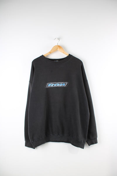 Vintage Reebok faded black crewneck sweatshirt features embroidered spell-out across the front