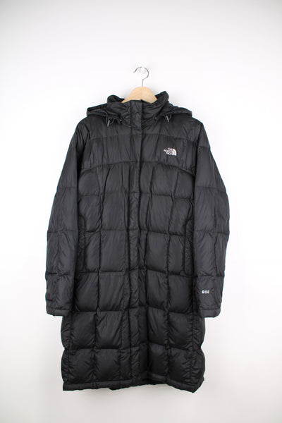 The North Face Long Puffer Jacket in a black colourway, zip up, insulated, side pockets, hooded and has the logo embroidered on the front and back.