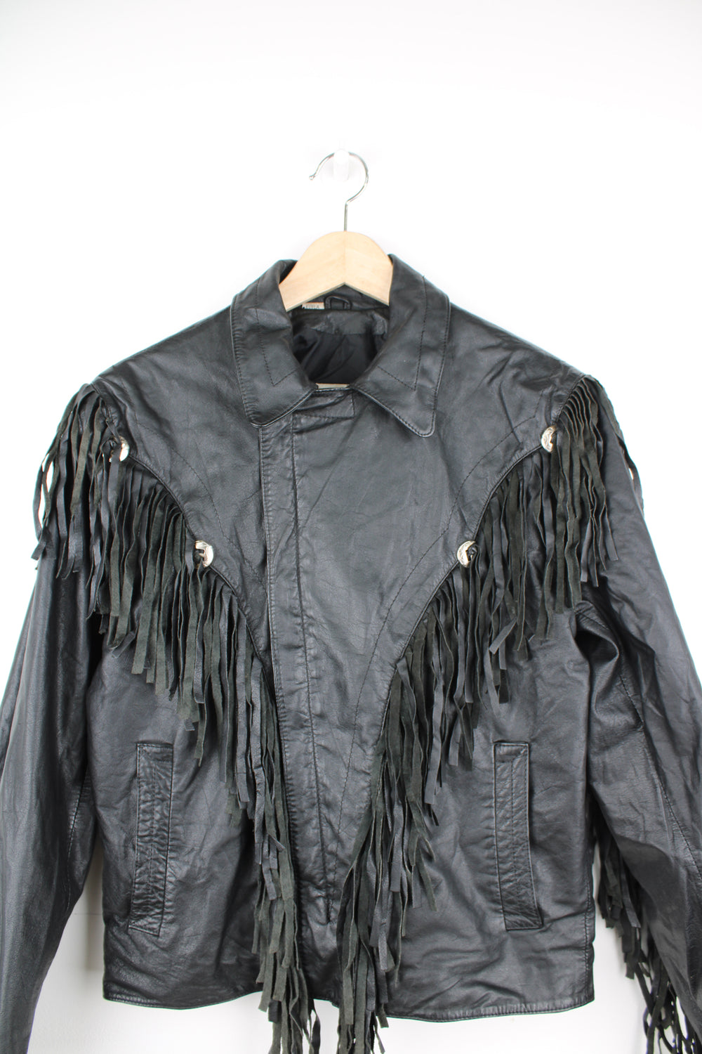 Vintage Wilson's black zip through leather jacket with fringe details on the back of the shoulders and silver conch buttons